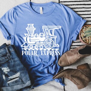 May include: A blue t-shirt with a white outline of a train and the words "Polar Express".
