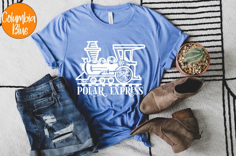 May include: A blue t-shirt with a white outline of a train and the words "Polar Express".