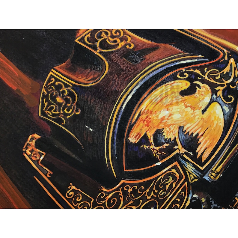 May include: A close-up of a vintage-style, ornate, black and gold musical instrument with an eagle design. The eagle is painted in shades of yellow and orange, with a dark blue background.