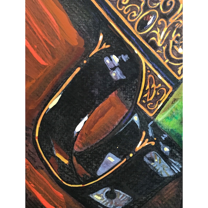 May include: Close-up of a black ceramic mug with gold trim. The mug is partially filled with a brown liquid. The background is a blurred image of a wooden surface.