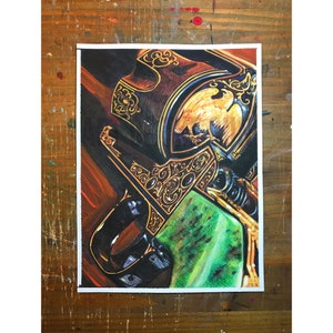 May include: A close-up of a detailed drawing of a gun with intricate gold and black designs. The gun is partially covered in a green and black pattern.