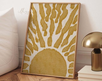 May include: A framed print of a stylized sun with yellow and white brushstrokes. The sun is centered in the print and has a yellow background.