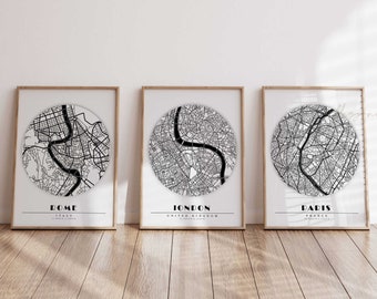 May include: Three black and white city map prints in wooden frames. The prints feature circular maps of Rome, Italy, London, United Kingdom, and Paris, France.