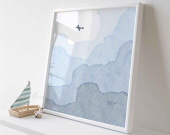 May include: A framed watercolor painting of a blue sky with clouds and a small airplane flying above. The painting is in a white frame and is on a white shelf.