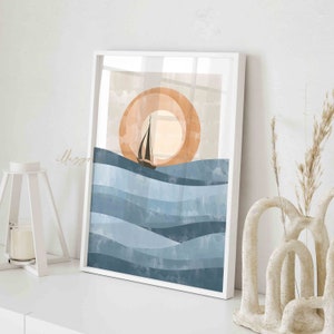 May include: A digital art print featuring a sailboat sailing on blue water waves with a large orange sun in the background. The print is framed in a white frame.