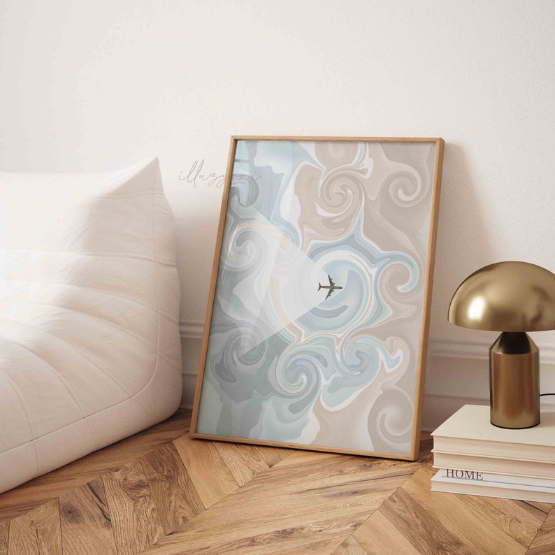 Puede incluir: Una impresi&oacute;n abstracta enmarcada con colores azul, gris y beige en espiral. Una peque&ntilde;a silueta de avi&oacute;n negro vuela por el centro de la impresi&oacute;n.