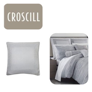May include: A silver gray bed set with a textured pattern. The set includes a duvet cover, two pillowcases, and a decorative pillow. The brand name "CROCILL" is displayed on a separate image.