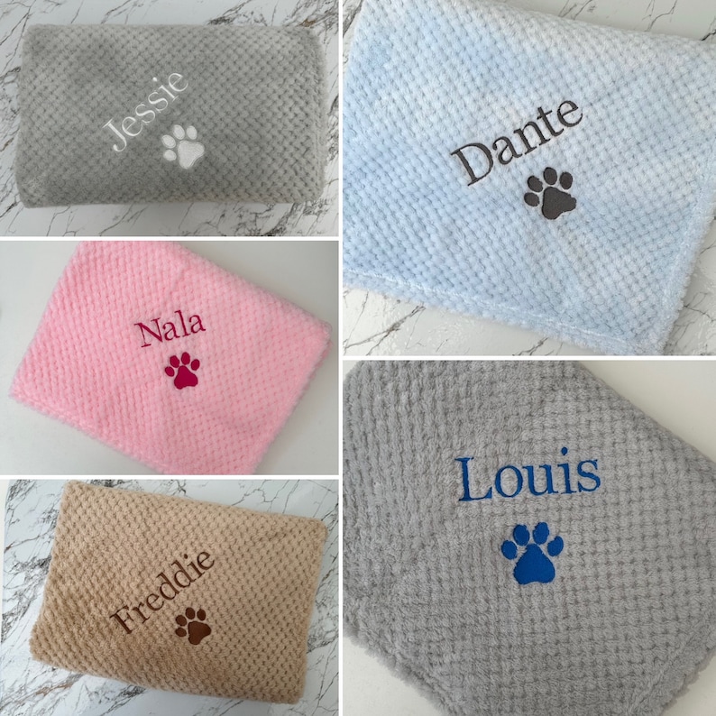 Pode incluir: Uma cole&ccedil;&atilde;o de cinco mantas macias e texturizadas em cinza, azul claro, rosa, bege e cinza escuro. Cada manta apresenta um nome bordado e um &iacute;cone de pata. Os nomes exibidos s&atilde;o Jessie, Dante, Nala, Freddie e Louis.