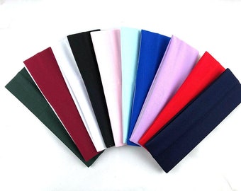 May include: Assortment of ten fabric headbands in various colours, including green, burgundy, white, black, pink, light blue, blue, lavender, red, and navy.