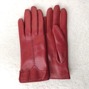 Puede incluir: Una taza de cer&aacute;mica blanca con un asa negra y el texto "But first, coffee" en un estilo manuscrito. La taza est&aacute; sobre una superficie blanca. La taza mide 10 cm de alto.