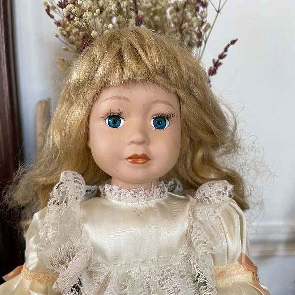 Belle poupée vintage Français en porcelaine. Belle robe lacée de couleur crème de ruban. Cheveux blonds épais. Poupées habillées de collection. Yeux bleus blonds