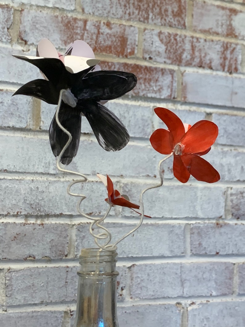 red and black paper flowers in repurposed bottle