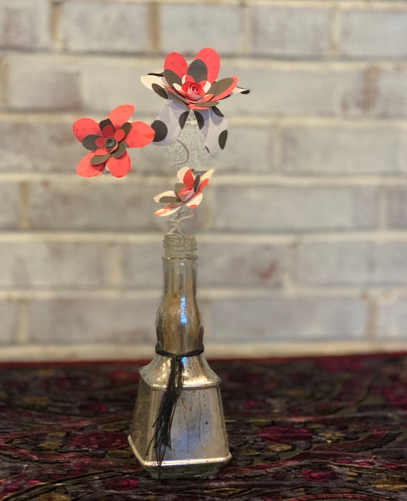 red and black paper flowers in repurposed bottle