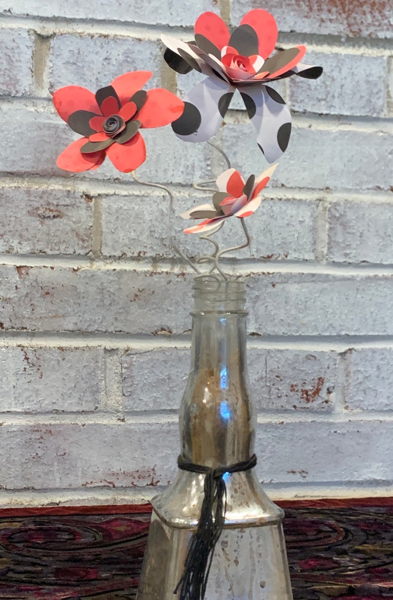 red and black paper flowers in repurposed bottle