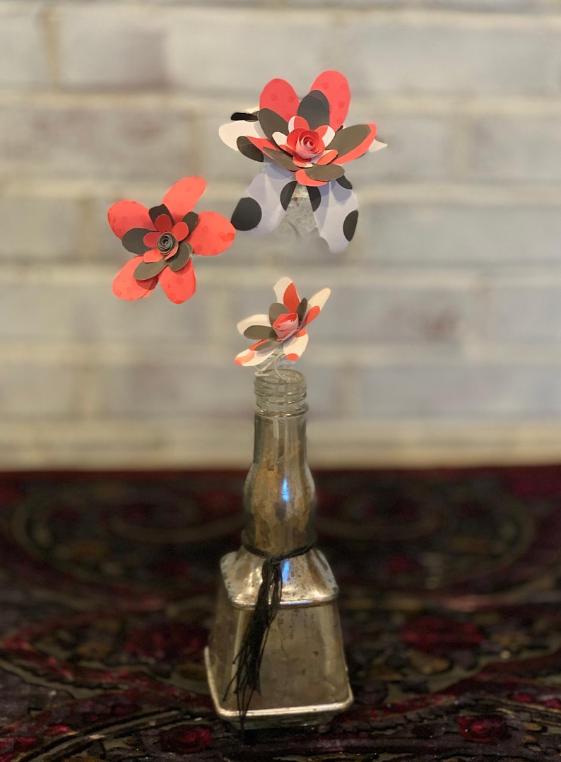 red and black paper flowers in repurposed bottle