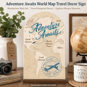 May include: An arched wooden sign featuring a vintage-style world map with the text Adventure Awaits in blue script. The design includes a dashed flight path, a small airplane icon, and a circular stamp graphic with an airplane and the text Welcome To The World.