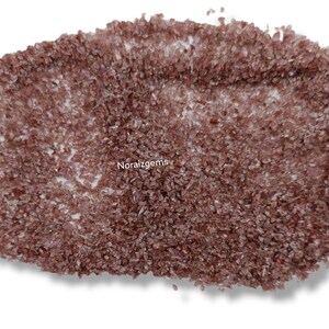K&ouml;nnte beinhalten: Eine Nahaufnahme eines Haufens kleiner, rotbrauner Kristalle. Die Kristalle sind unregelm&auml;&szlig;ig geformt und haben eine leicht durchscheinende Optik.
