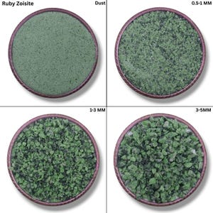 Puede incluir: Cuatro recipientes circulares muestran Ruby Zoisite en diferentes tamaños. Arriba a la izquierda, polvo; arriba a la derecha, 0,5-1 mm; abajo a la izquierda, 1-3 mm; y abajo a la derecha, 3-5 mm. Cada recipiente tiene un borde marrón oscuro y está lleno de material verde granular.