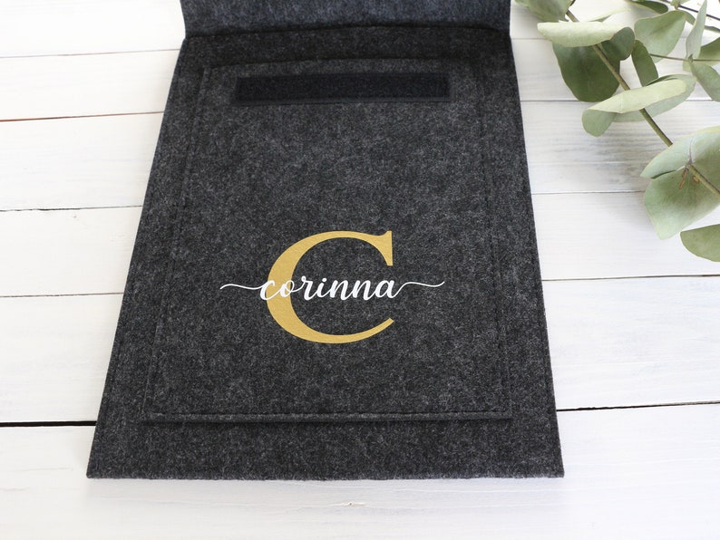 May include: A gray felt storage pouch with a gold letter C and the name "corinna" in white script.