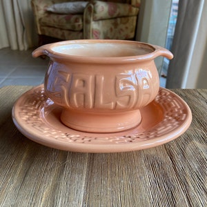 May include: A peach-colored ceramic salsa dish with a matching saucer. The dish has the word "SALSA" embossed on the front.