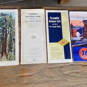 May include: Four vintage road maps, two of Yosemite National Park and part of San Joaquin Valley, one of Sequoia National Park, and one of the United States Western States. The maps are printed in black and white with red and blue accents. The maps are all in good condition and have a vintage look.
