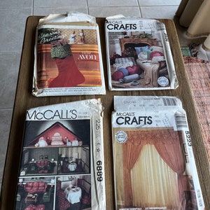 May include: Four vintage sewing patterns for crafts projects. The patterns are for a Christmas stocking, pillows, curtains, and a dollhouse. The patterns are all from McCall's Crafts.