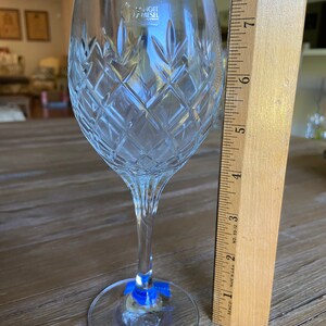 May include: A clear glass wine glass with a cut crystal design. The glass is 17.8 cm tall and has a Schott Zwiesel logo on the side.