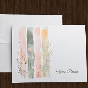 May include: A white card with a watercolor design of pink and green vertical stripes with small flowers and the name "Alyssa Brown" printed at the bottom.