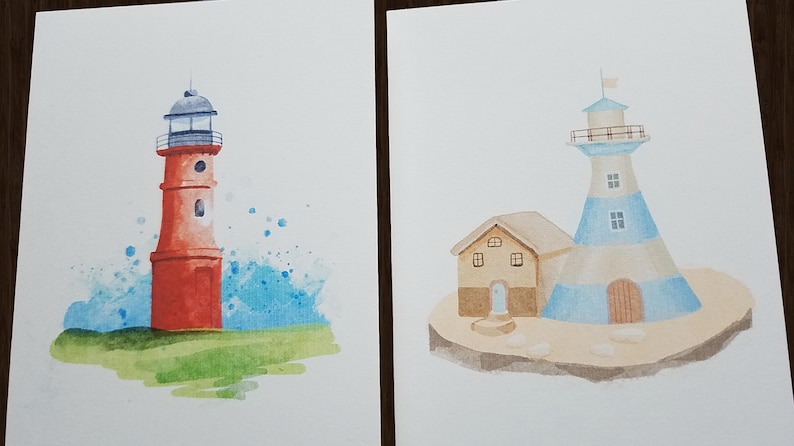 Peut inclure: Deux aquarelles de phares. La premi&egrave;re peinture montre un phare rouge avec un sommet blanc et un fond d'aquarelle bleu. La deuxi&egrave;me peinture montre un phare ray&eacute; bleu et blanc avec une petite maison brune &agrave; c&ocirc;t&eacute;.