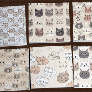 May include: Six square notebooks with cat-themed designs. The patterns include repeating cat faces in various colors, sleeping cats, and cat faces with floral accents. The color palette is neutral with shades of gray, beige, and white.