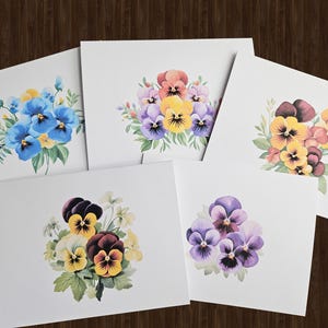 May include: Five cards with watercolor paintings of different colored pansies. Each card features a bouquet of pansies in shades of blue, purple, yellow, orange, and brown.