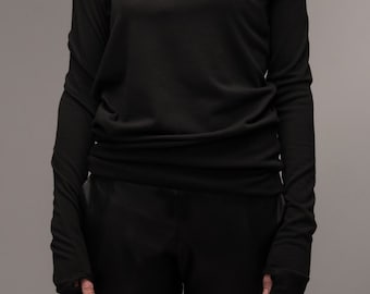 May include: A black long-sleeved shirt with a high, gathered neckline and thumbholes at the cuffs.