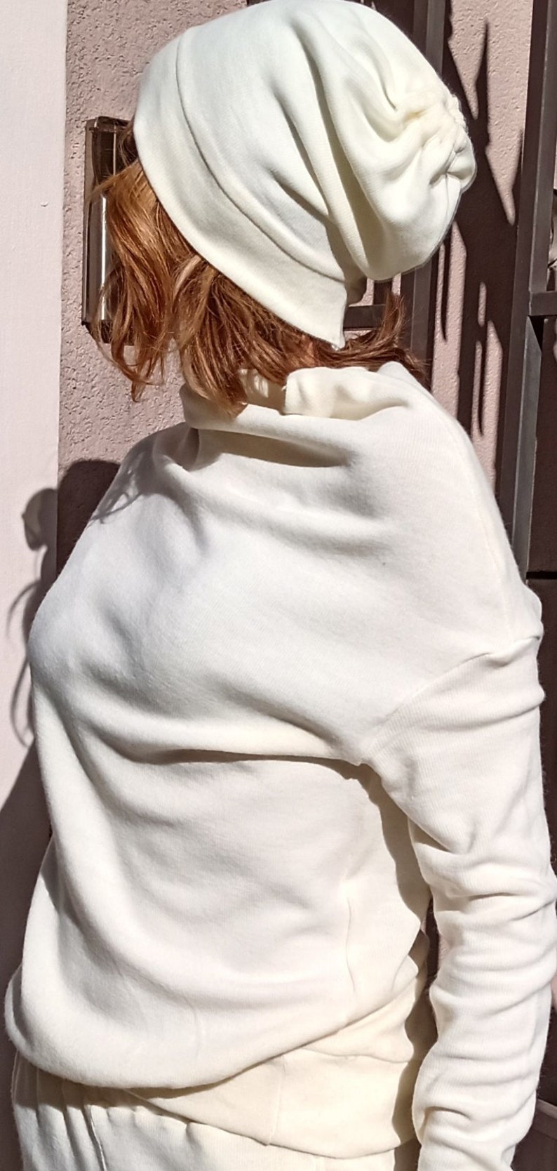K&ouml;nnte beinhalten: Eine wei&szlig;e, weiche Beanie-M&uuml;tze im Slouchy-Stil mit schlichtem Design. Die M&uuml;tze ist aus einem weichen, komfortablen Material gefertigt und perfekt f&uuml;r den t&auml;glichen Gebrauch.