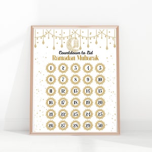 May include: A printable countdown calendar for Ramadan with gold and white accents. The calendar features a crescent moon and lantern design and the text "Countdown to Eid Ramadan Mubarak".