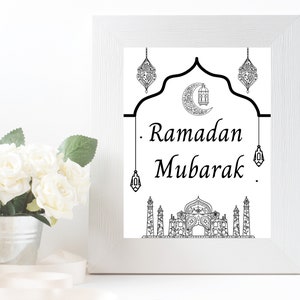 May include: A black and white printable art print with a crescent moon, mosque, and lanterns. The text reads "Ramadan Mubarak".