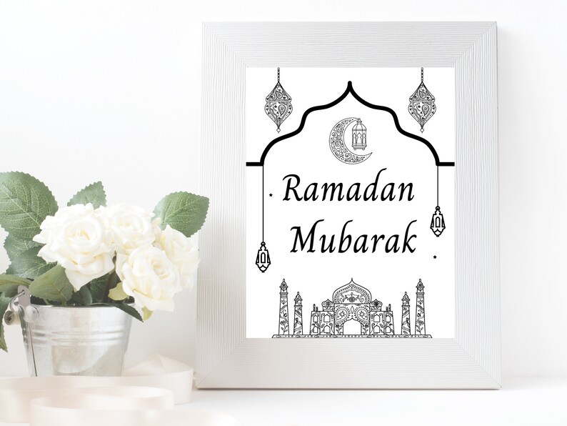 May include: A black and white printable art print with a crescent moon, mosque, and lanterns. The text reads "Ramadan Mubarak".