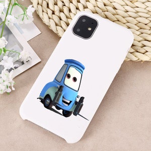 Puede incluir: Carcasa de tel&eacute;fono blanca con una imagen de dibujos animados de una carretilla elevadora azul con una cara sonriente. La carcasa del tel&eacute;fono tiene un recorte para la c&aacute;mara en la esquina superior izquierda.