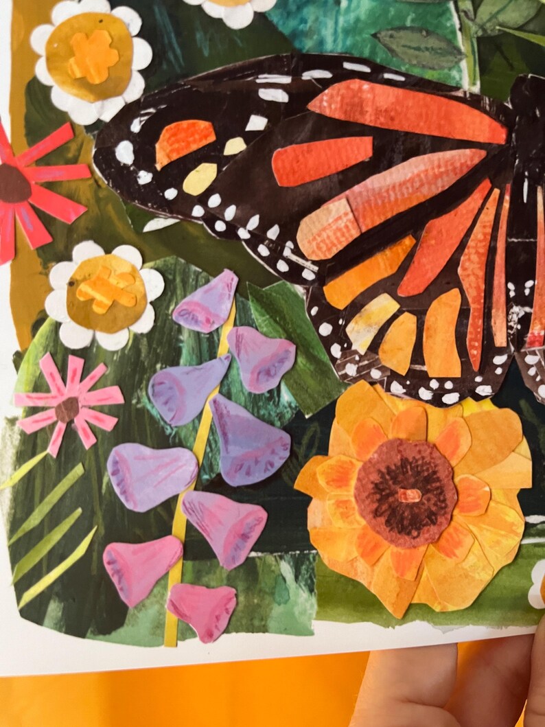 May include: A mixed-media collage artwork featuring a large monarch butterfly with black and orange wings positioned above a garden scene. The composition includes white daisies with yellow centers, a large orange flower, and purple bell-shaped flowers.