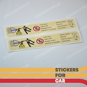 May include: Two yellow warning stickers with black text and graphics. The stickers warn about high voltage and the dangers of touching a light. The text on the stickers reads "Licht aus! Lights off! ¡Apagar la luz! Eteindre la lumière!" and "Bedien.Anltg. Manual Instrucciones Instruction".