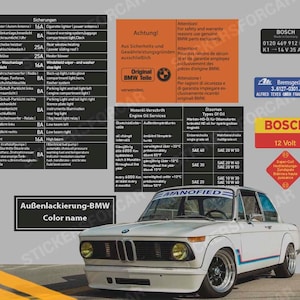 Peut inclure: Une BMW 2002 blanche des années 1970 avec une bande noire sur le côté. La voiture a un pare-chocs noir et des roues noires. La voiture est garée sur une surface grise. L'image comprend également une feuille d'autocollants avec des informations sur la voiture, notamment la pression des pneus, l'huile moteur et les informations sur la boîte à fusibles.