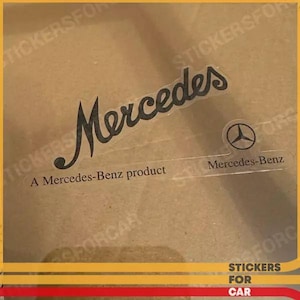 Puede incluir: Una pegatina transparente con la palabra "Mercedes" en cursiva. Debajo está el texto "A Mercedes-Benz product". También se ve un pequeño logotipo de Mercedes-Benz. La pegatina es para coches.