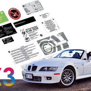 Op de afbeelding: Een witte BMW Z3 cabriolet met een zwart kenteken dat "89 167" aangeeft. De auto is omringd door verschillende informatieve stickers en labels, waaronder een sticker met de tekst "BMW Service Hotline 0130-3332".