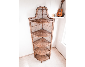 May include: A brown wicker corner shelf unit with five shelves. The shelf unit is made of woven wicker and has a curved top.