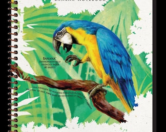 Könnte beinhalten: Ein Spiralnotizbuch mit einer farbenfrohen Illustration eines blau-gelben Aras auf einem Ast. Auf dem Cover steht "Essence of Nature Banana Notebook" und "Banana Environmentally Friendly Paper 80 Sheets".
