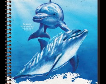 May include: A spiral-bound notebook with a blue dolphin illustration. The cover reads "Essence of Nature Banana Notebook" and includes text about environmentally friendly paper and saving trees. The notebook contains 80 sheets.