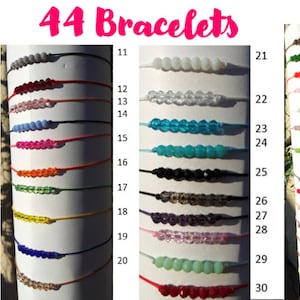 May include: 44 bracelets with different colored beads on string. The bracelets are numbered 1 through 44.