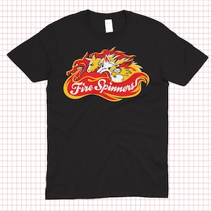 Pode incluir: Camiseta preta com um gráfico de três animais estilizados com chamas e o texto "Fire Spinners" em um design vermelho e amarelo. A camisa é um estilo de gola redonda.