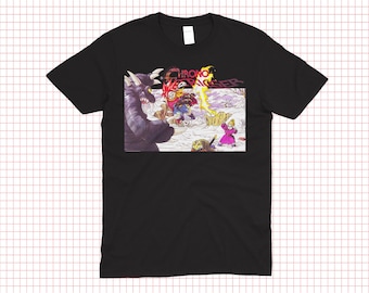 May include: Black t-shirt featuring a colorful graphic from the video game Chrono Trigger. The design includes characters and the game's logo. The artwork depicts a battle scene with a purple monster and other figures.