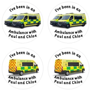 May include: Four round stickers featuring a yellow ambulance with green and white chequered markings. The text on the stickers reads "I've been in an ambulance with Paul and Chloe".