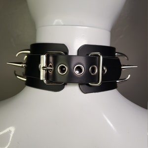 May include: Black leather choker with silver metal spikes and a buckle closure.